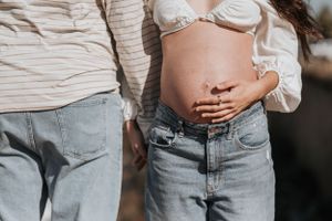 Intimate beach photoshoot featuring coordinated outfits of distressed denim and white tops.