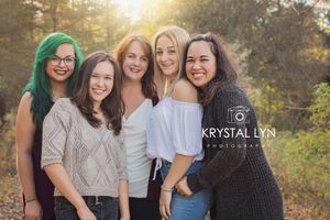 Close up photo of Mom and her older daughters with the golden sun behind them