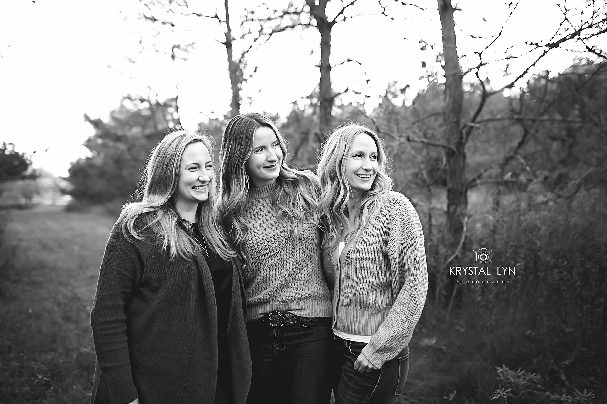 Stunning black and white of three sisters smiling ahead at their families