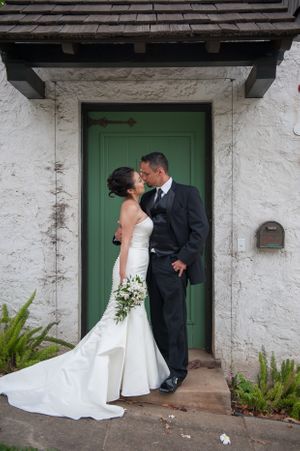 Bridal couple in front of green door.