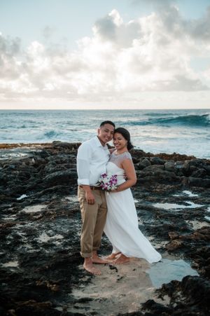 Casual wedding couple on lava rocks at Sandys