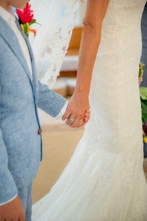 bride walking with young boy in blue suit shot of them holding hands