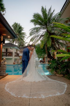 Bride and groom looking over their shoulders. standing by a pool