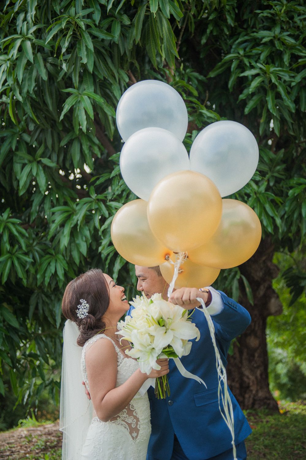 gold and white balloons with bride and groom