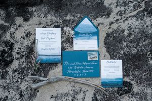 Blue and white wedding invitations on rock