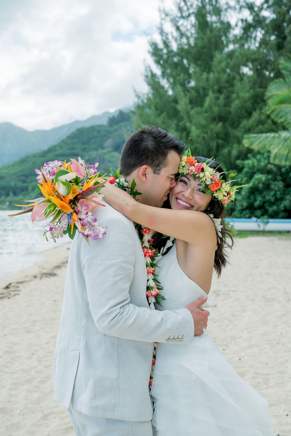 Bride and groom snuggling at Kualoa Beach