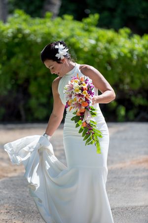 Bride fluffing her dress before heading down the aisle at the beach