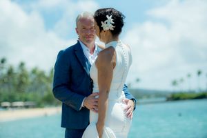 Groom looking at the camera holding his bride