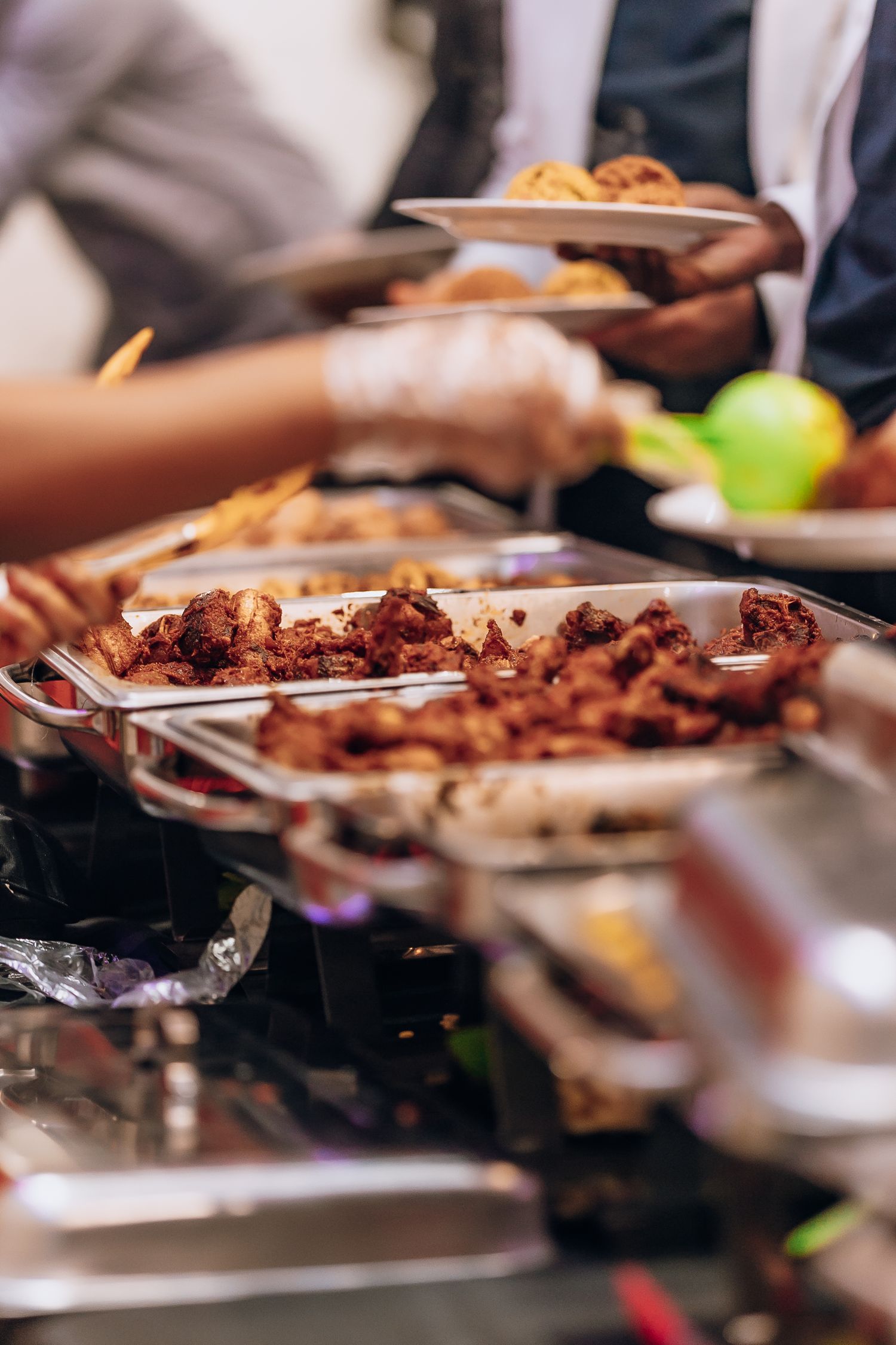 Buffet setup with plates of grilled meat and food being served.