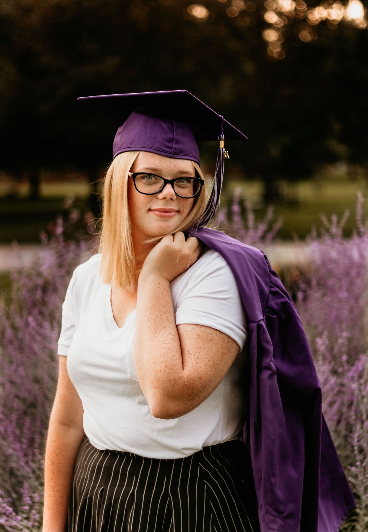 High School Senior with her cap and gown on in the park