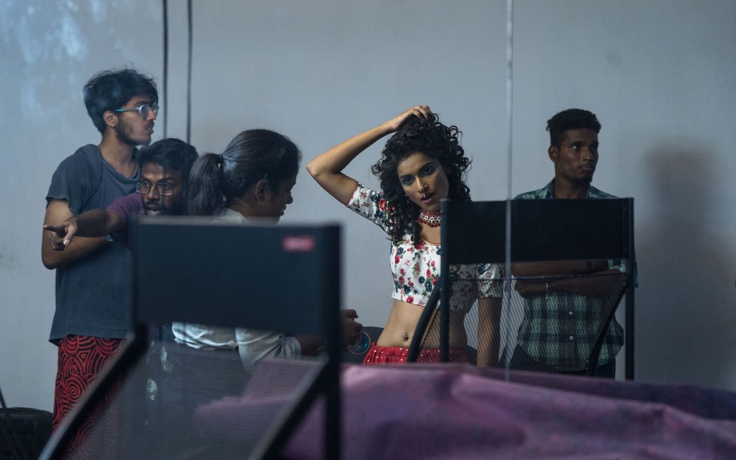People gathered in a studio setting with chairs and equipment visible.