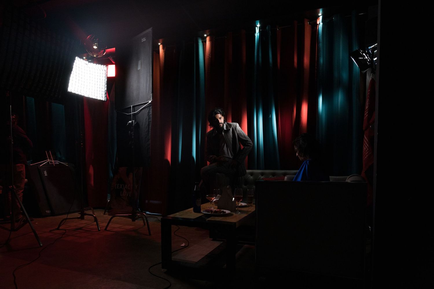 Dramatic stage lighting creates colorful streaks in a dark performance space with professional equipment setup.