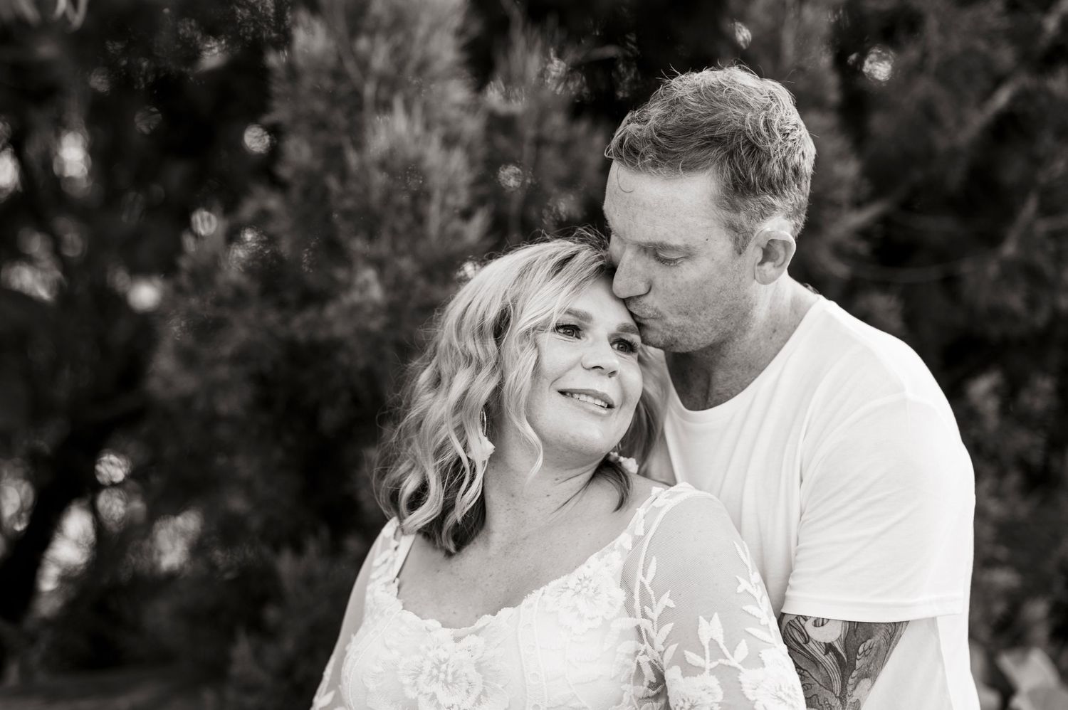 Black and white romantic outdoor portrait of a couple sharing an intimate moment.