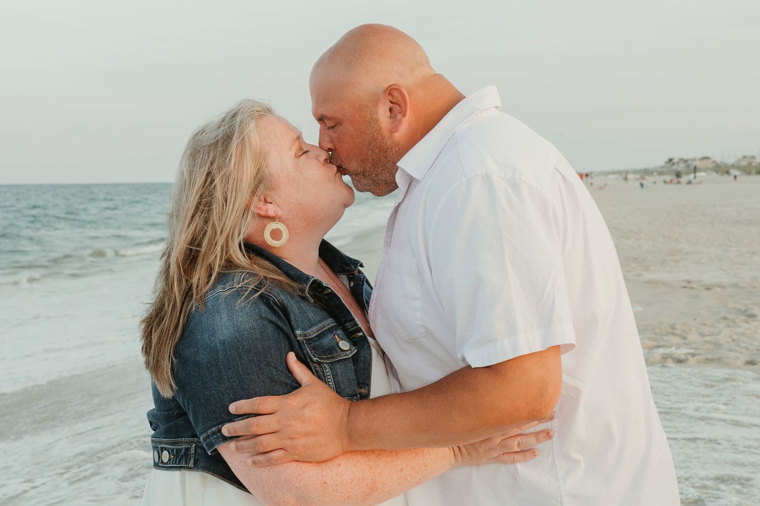 Couple sharing intimate moment on beach at sunset.
