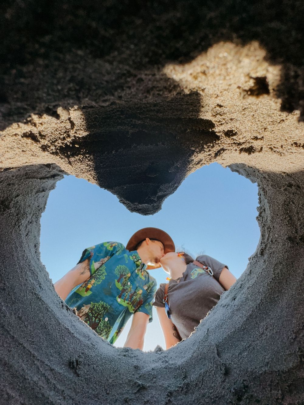 Looking up through a hole in the ground at people peering down.