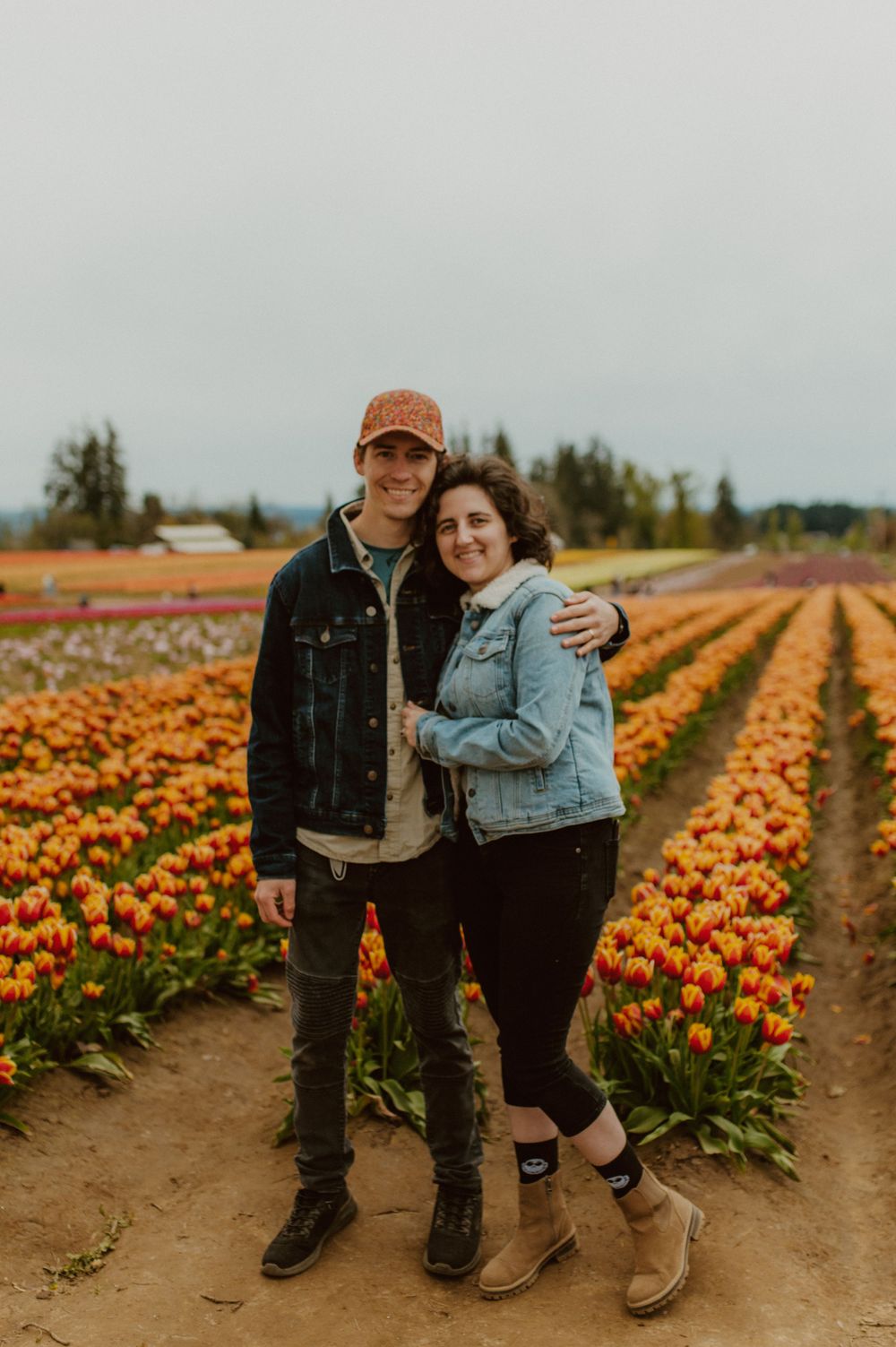 Couple posing together in a colorful tulip field during springtime.