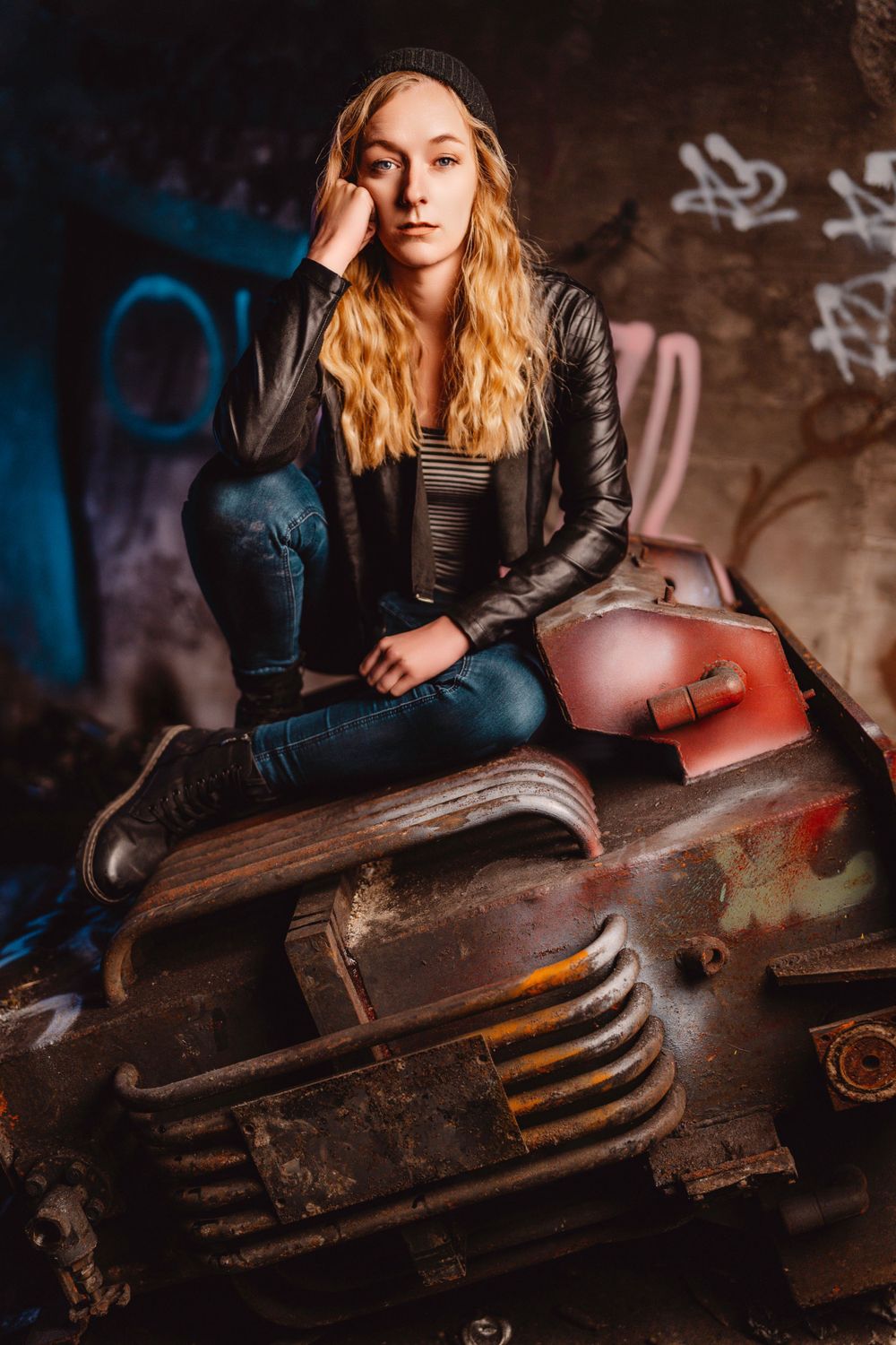 Artistic portrait series featuring leather jacket against rustic background with vintage suitcase.