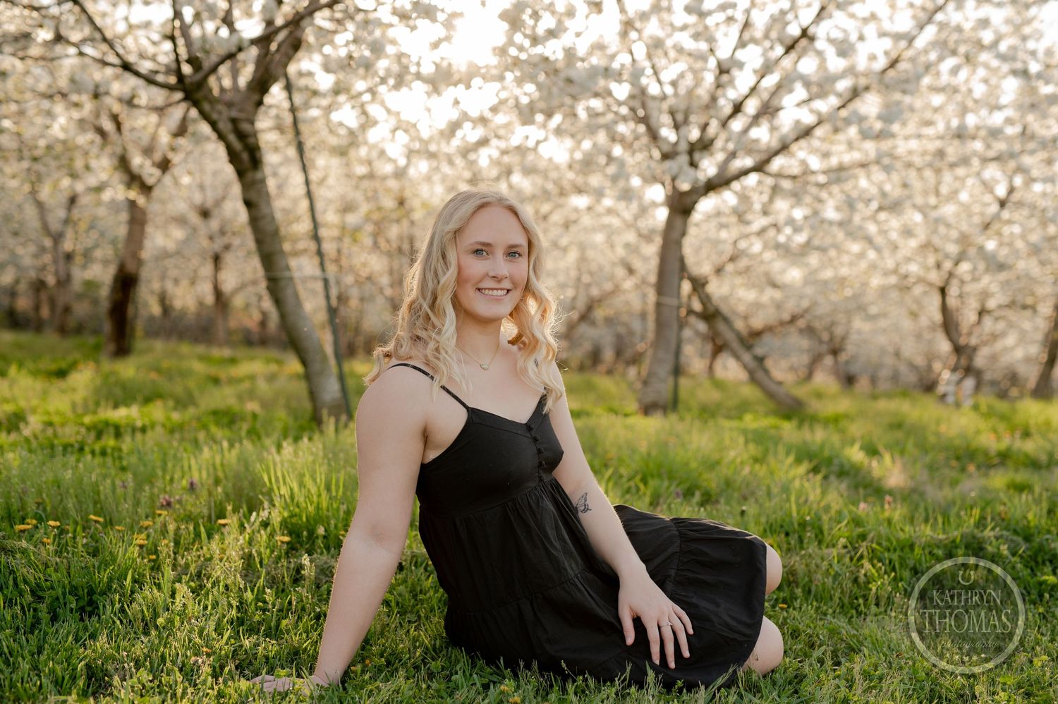 Casual outdoor portrait among blooming spring trees with soft natural lighting.