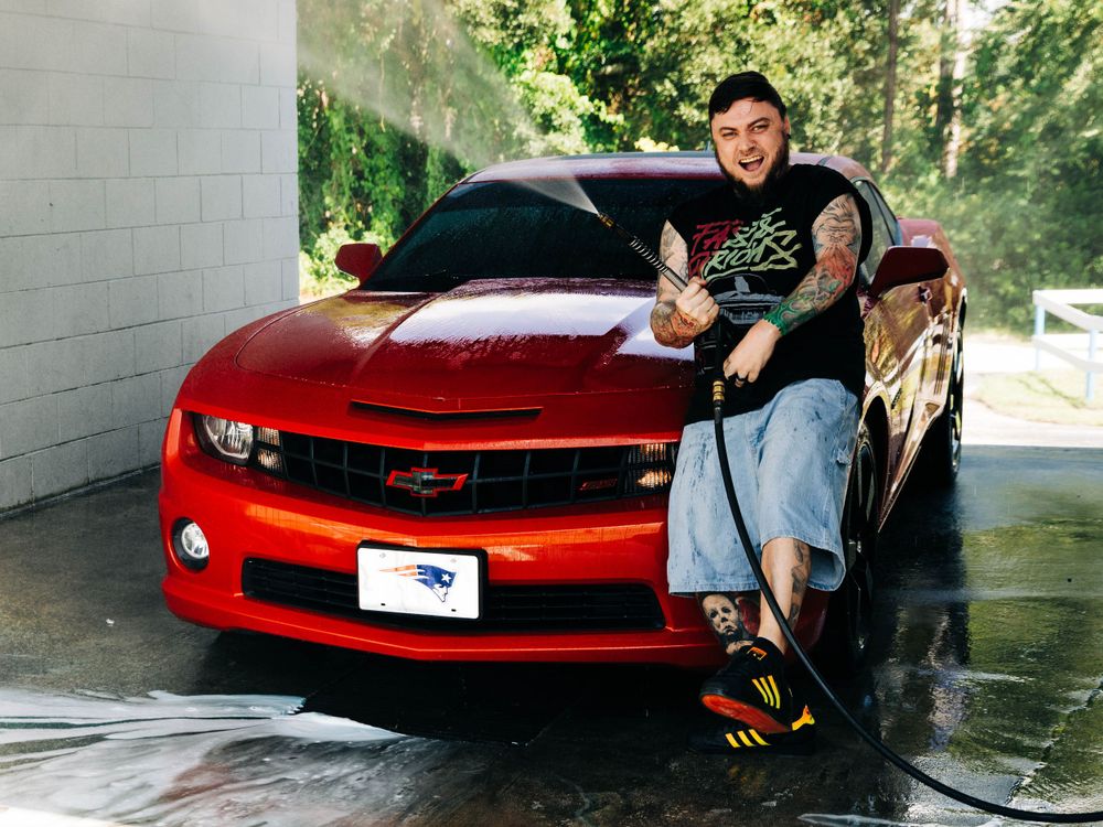 Red Chevrolet Camaro being washed at a carwash.