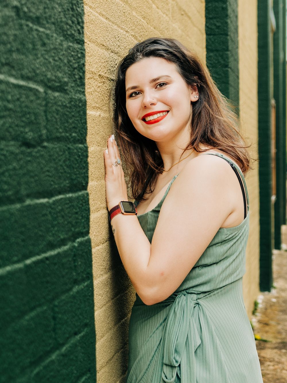 A summer portrait against a green and yellow painted wall.
