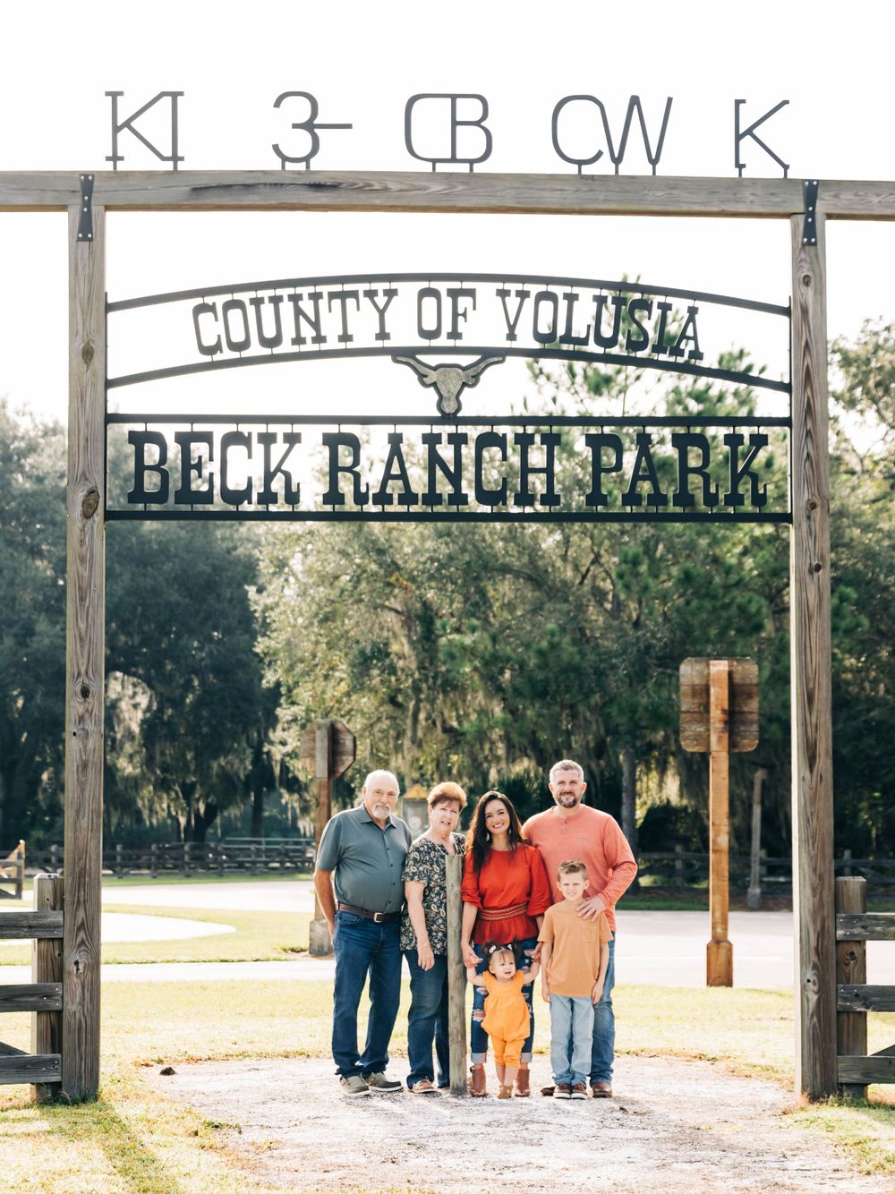 Family stands under rustic wooden entrance sign at Beck Ranch Park in Volusia County.