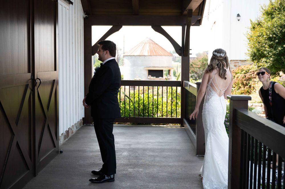 Covered porch scene with wooden beams and railing overlooking outdoor area.