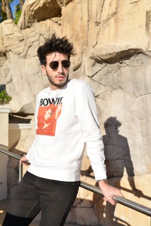 David Bowie graphic sweatshirt worn against desert rock formation.