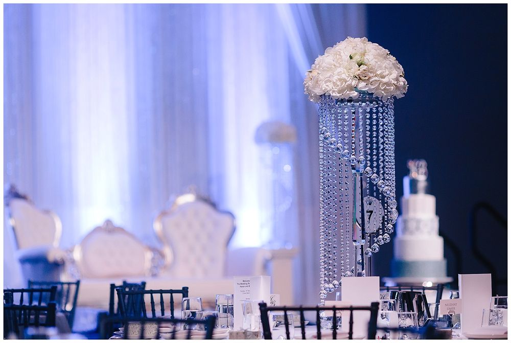 Luxury wedding centerpiece featuring crystal chandelier drops and white floral arrangements.