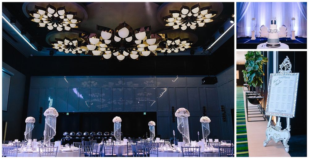 Modern wedding reception venue with floral ceiling lights and crystal centerpieces on guest tables.