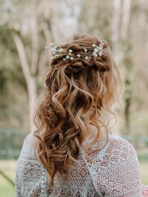 Halb hochgesteckte Brautfrisur mit Locken und Schleierkraut