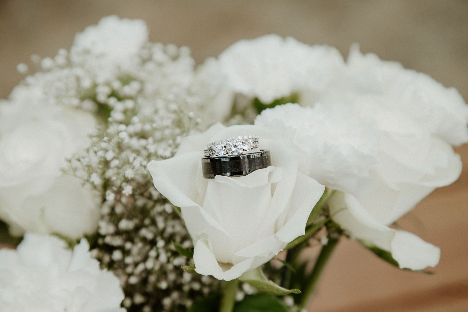 wedding ring bands placed on top of bouquet