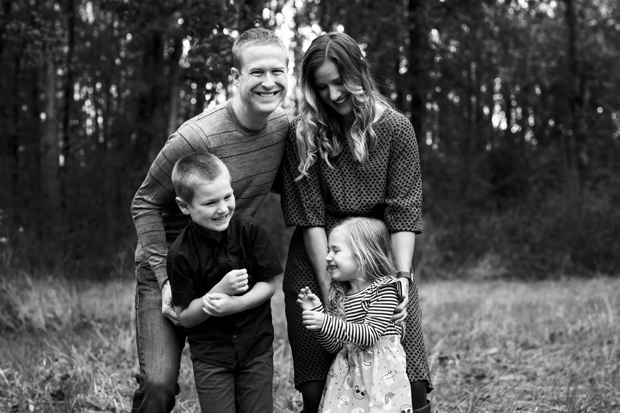 Family laughing and tickling each other at candid family photo shoot