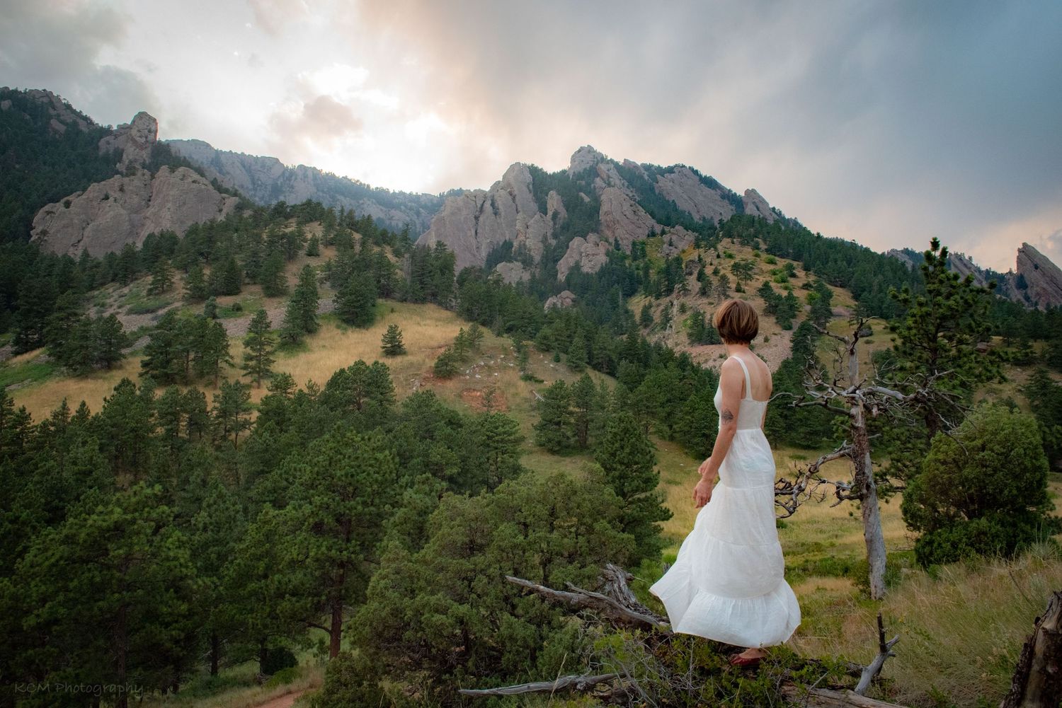Adventure shot out in nature in the Flat Irons in Colorado at sunset with a girl in a white dress