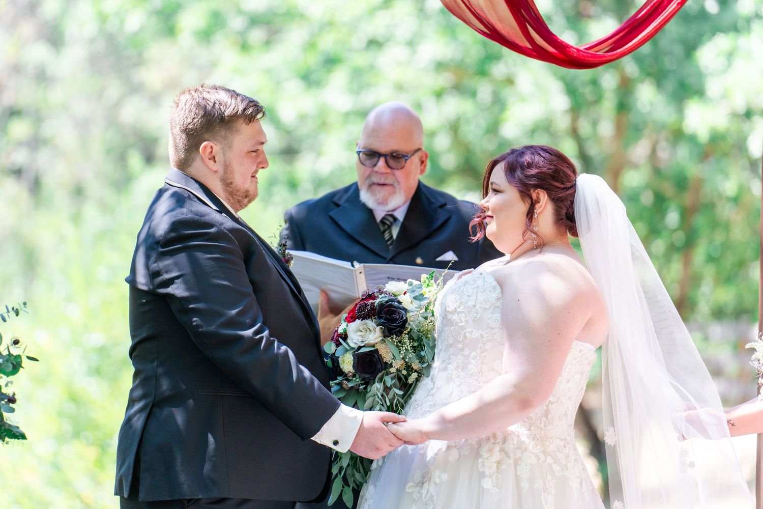 bride and groom hold hands during ceremony