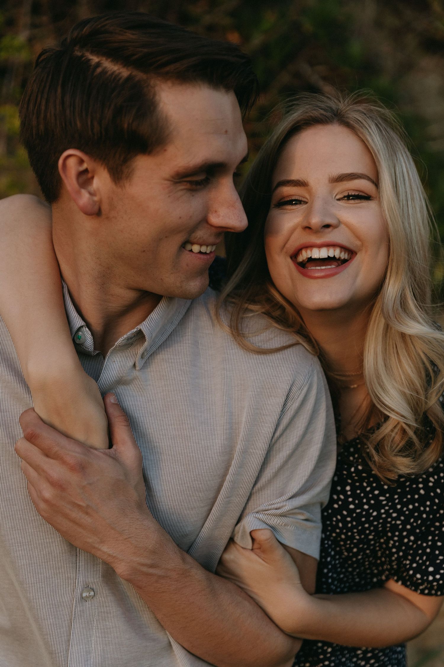 A joyful moment captured between a couple in casual attire outdoors.