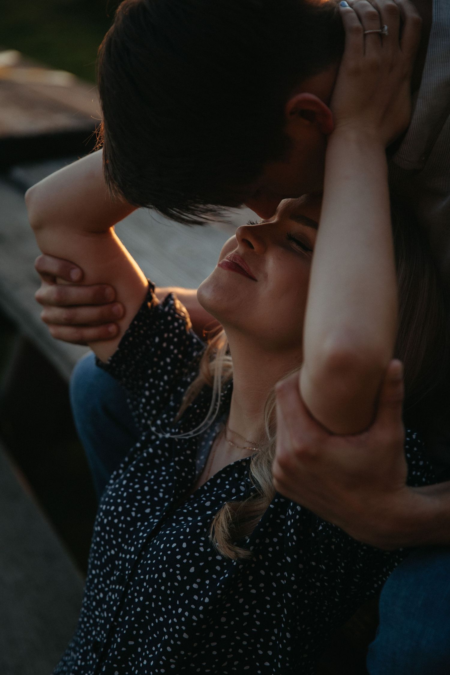 A romantic sunset moment between a couple in casual attire.