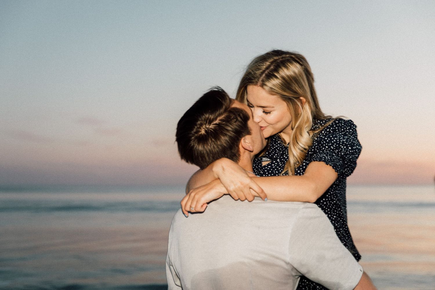 Intimate beach photoshoot of a couple sharing an embrace during golden hour.