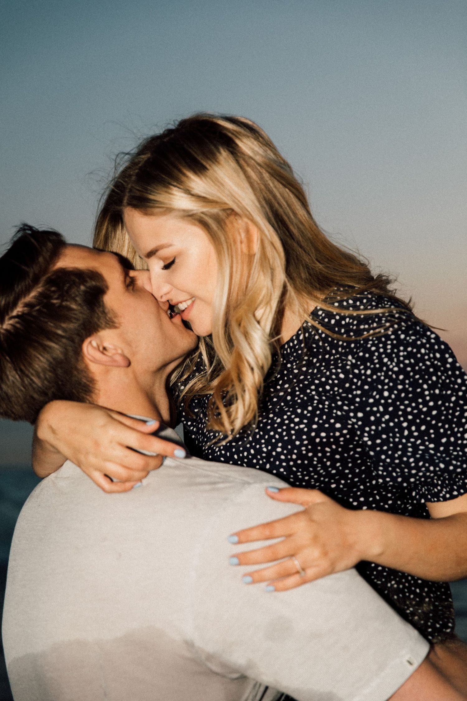 Joyful couple sharing a romantic moment at the beach during sunset.