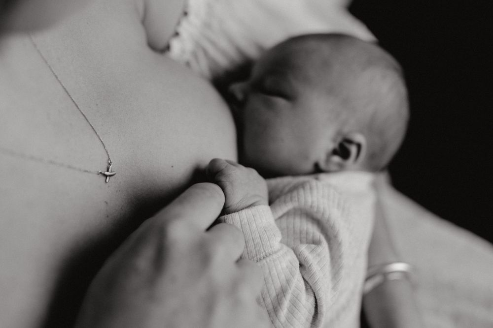 Close-up black and white portrait of sleeping infant in gentle lighting.