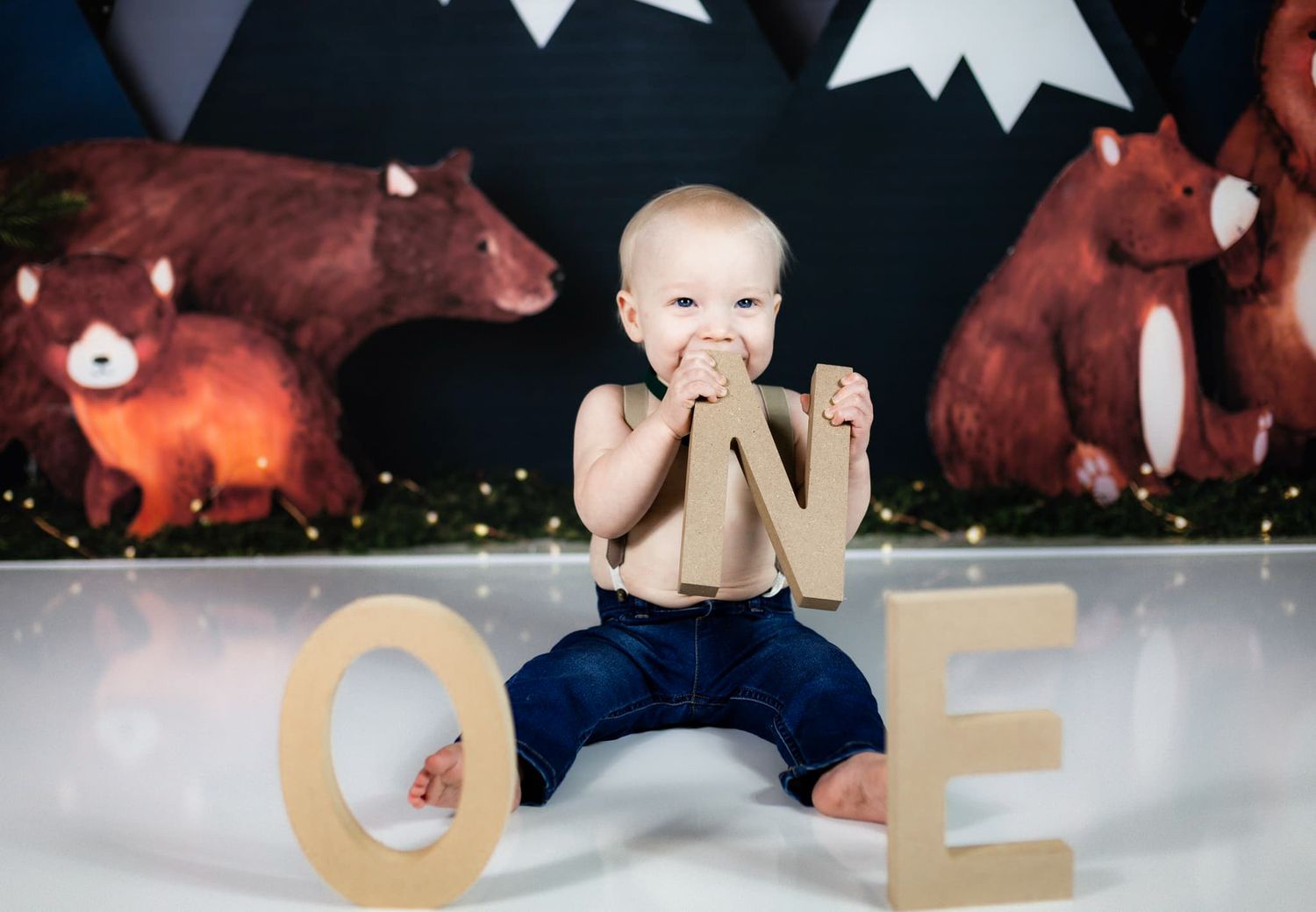 Baby milestone photo with wooden letters spelling out AGE against dark background.