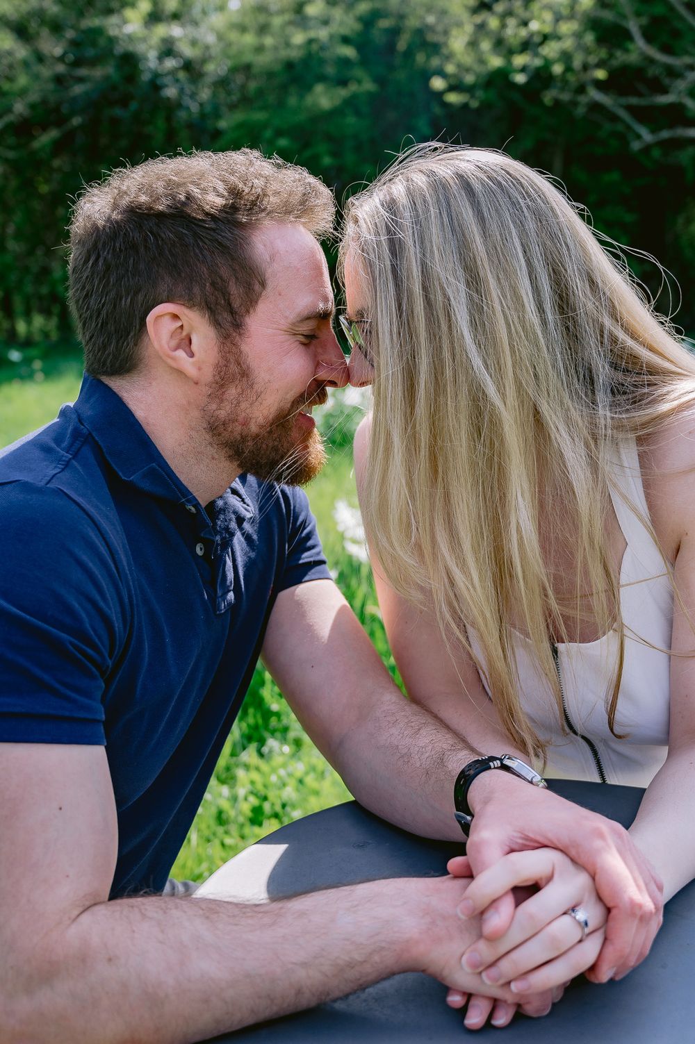 Intimate close-up of couple sharing tender moment in garden setting.