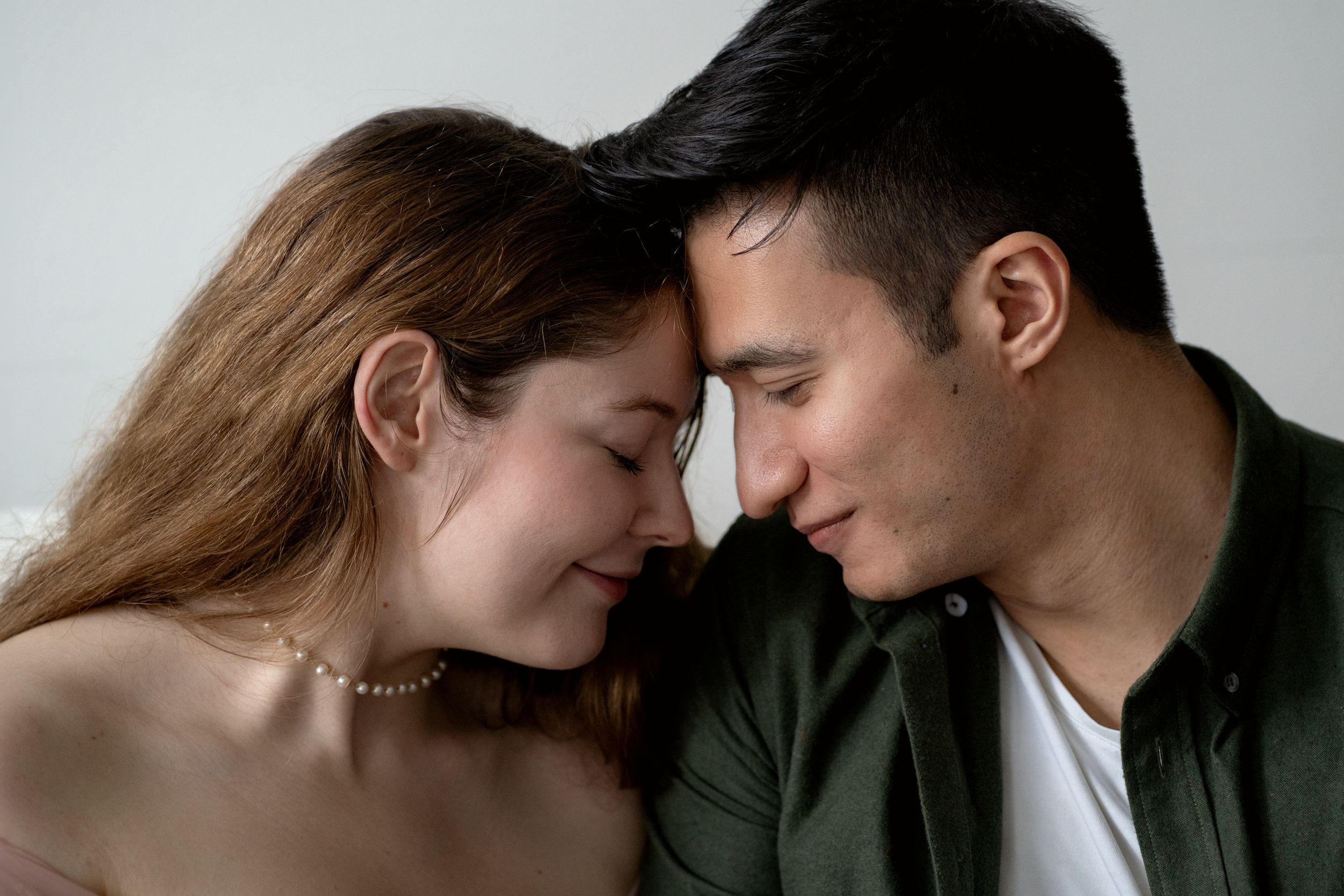 Intimate romantic couple portrait series against gray background showing tender moments.
