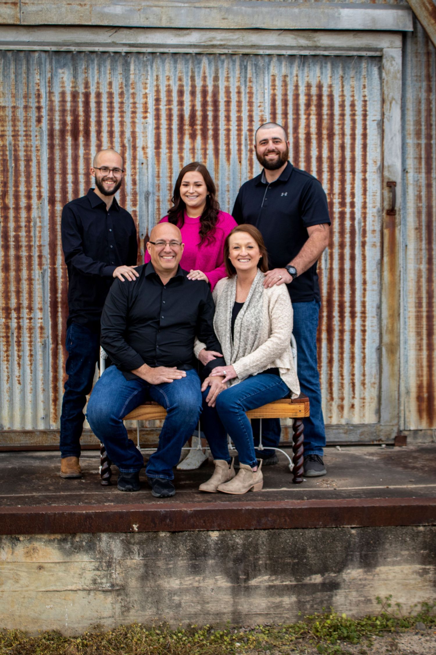 family with older children posing in front of an old building