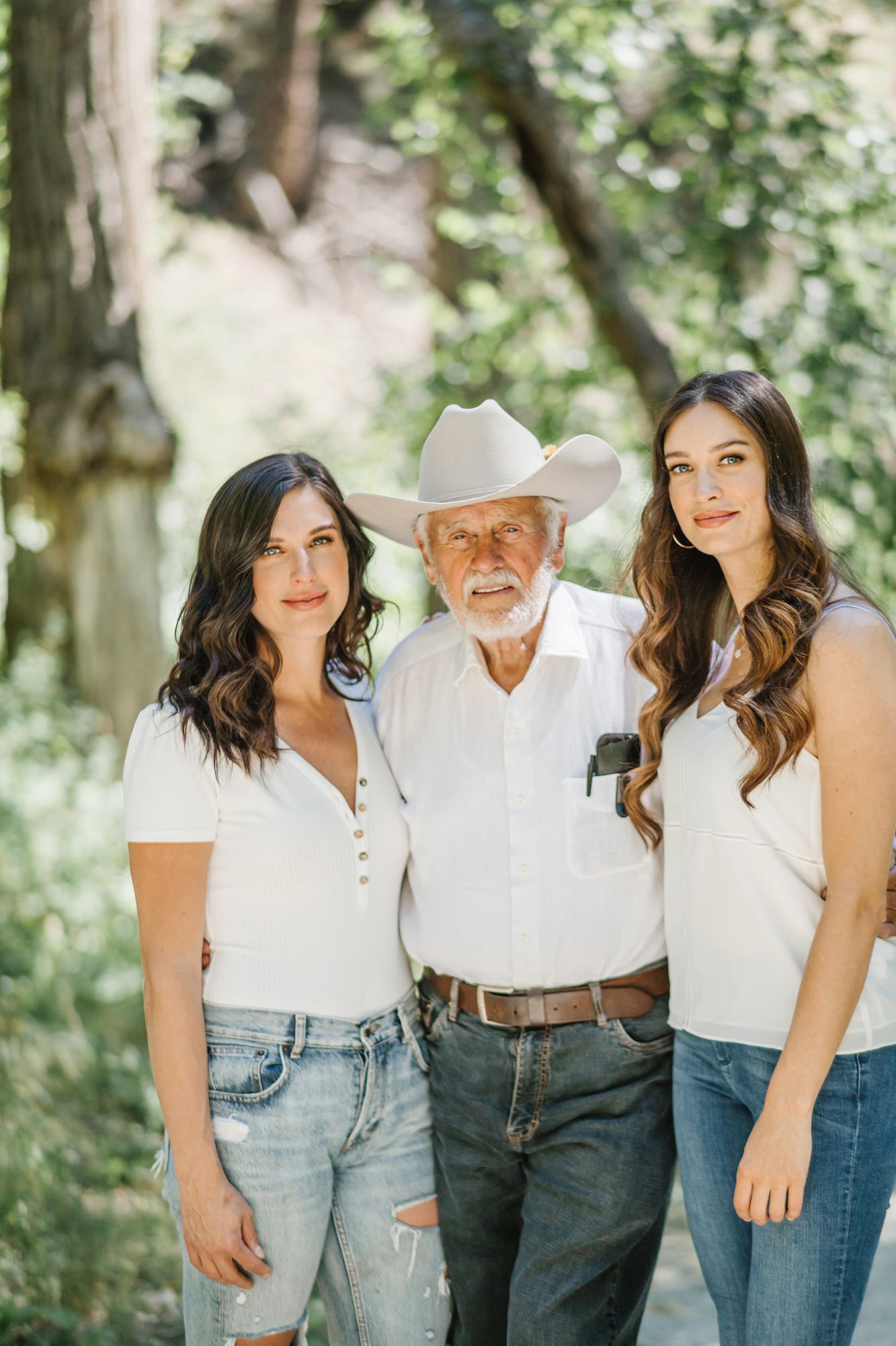 A family portrait in a wooded setting with casual western style clothing.