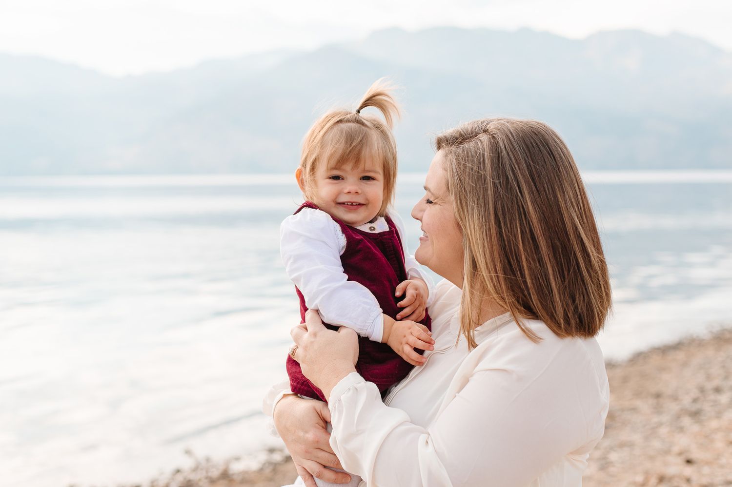 Mother and child share tender moment at beach during portrait session.