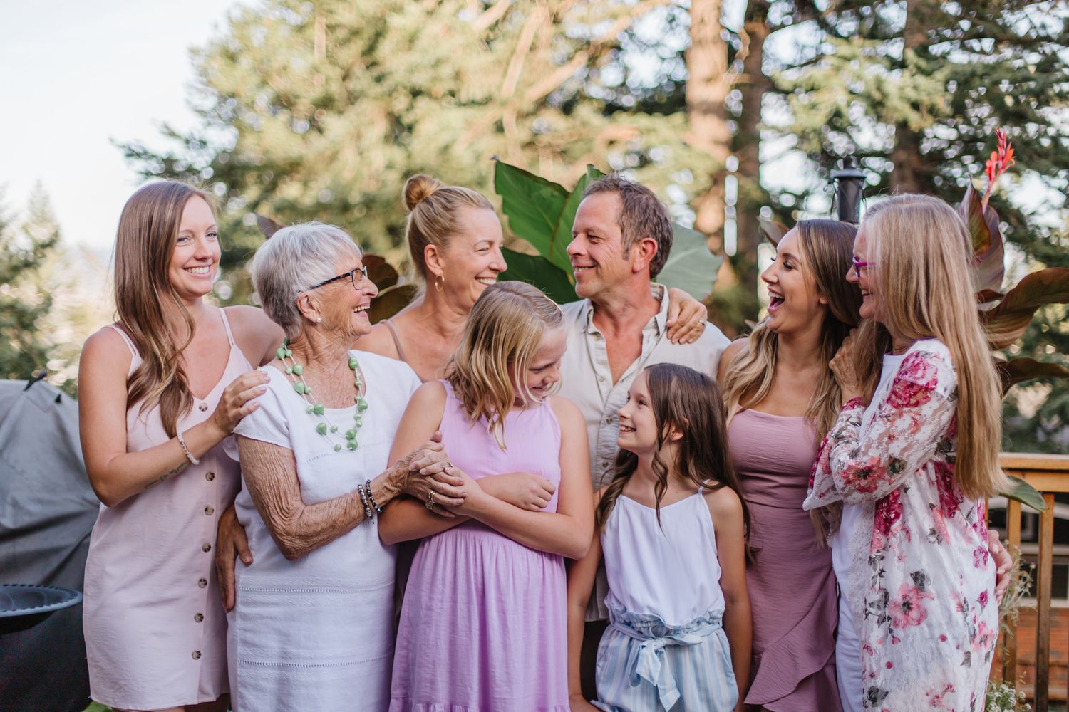 Group gathered together outdoors wearing coordinated pink and floral dresses.