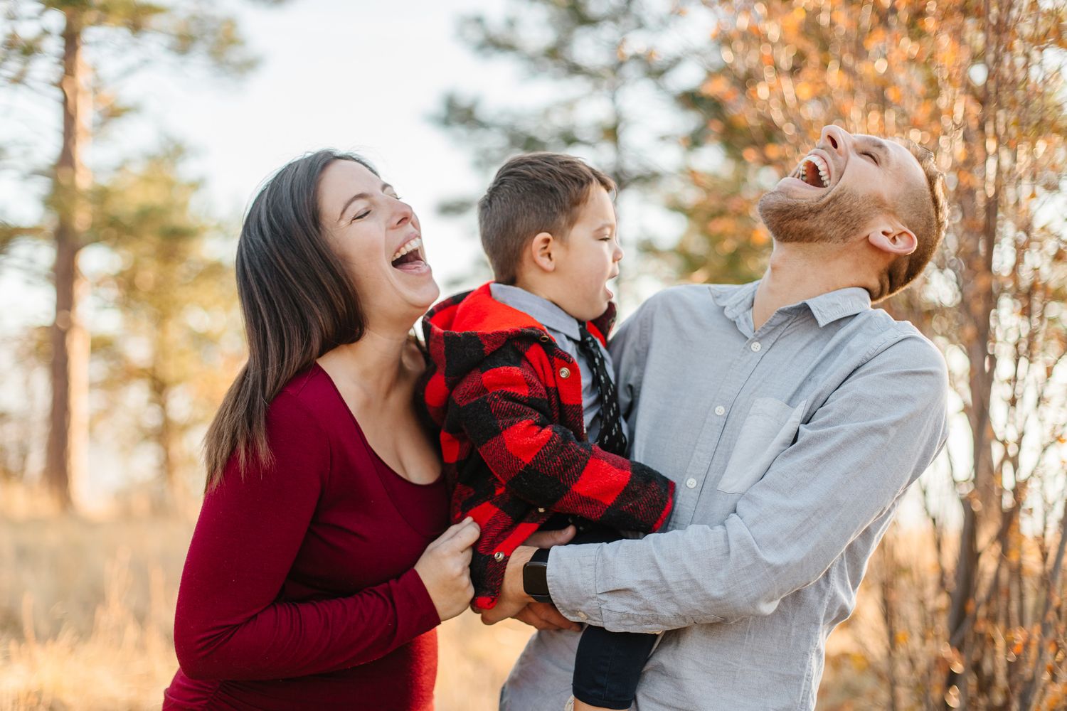A playful outdoor family photoshoot with matching burgundy outfits at golden hour.