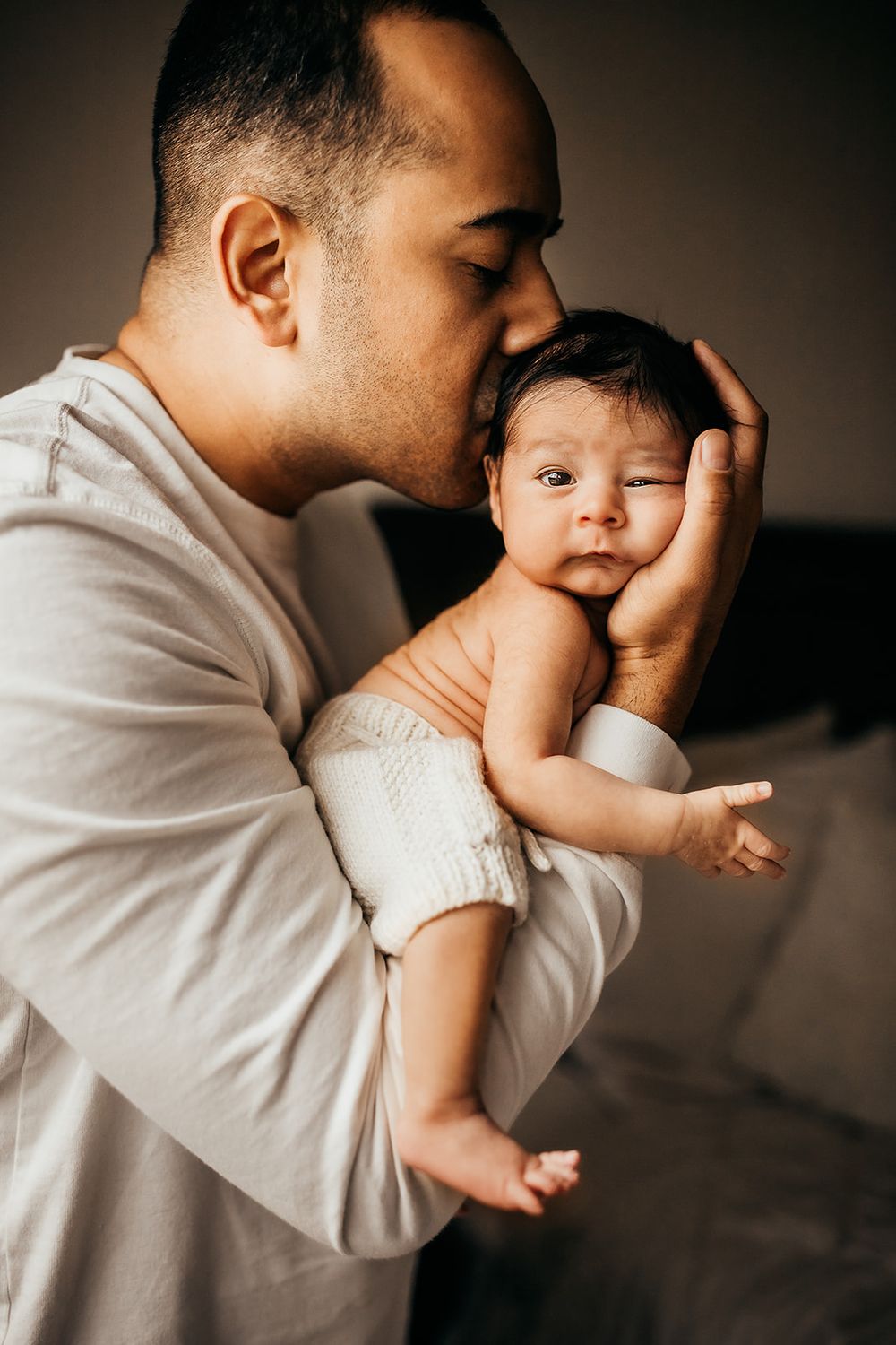A dad holds his baby boy during newborn session on Oahu, Hawaii.