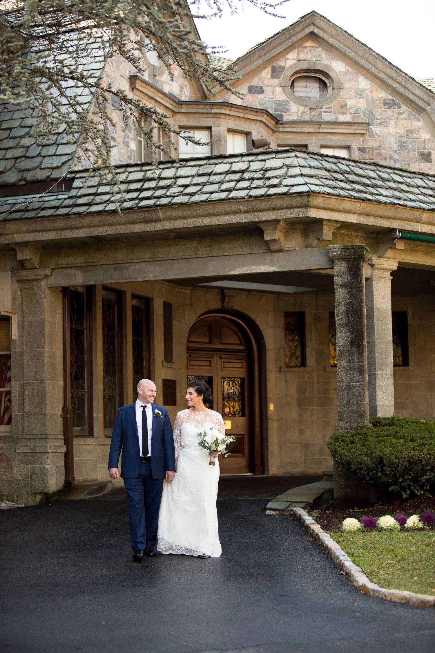 An elegant stone mansion entrance with classic architectural details and landscaping.