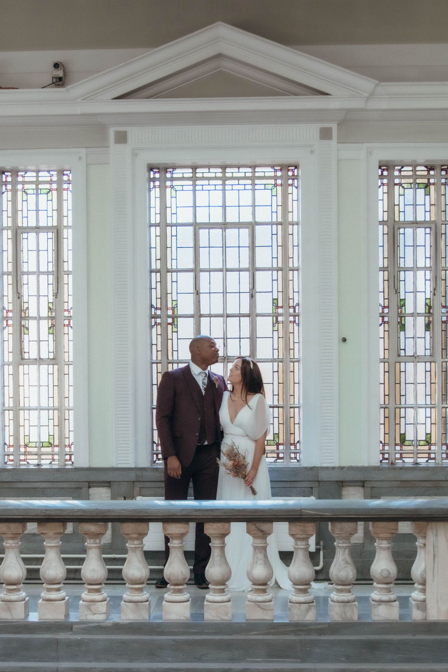 Bride & Groom standing in front of the windows in Islington Town Hall
